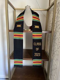 a scarf with the words class of 2013 on it sits on a shelf in front of a white wall