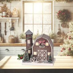 a wooden table topped with a red barn next to a christmas tree