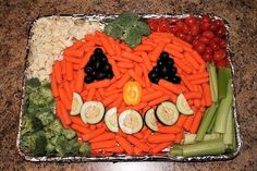 a plate with carrots, celery and other vegetables in the shape of a jack - o'- lantern