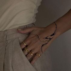 a woman's hand with tattoos on her left arm and the other half of her pants