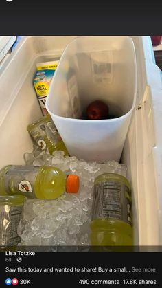 an open refrigerator filled with lots of ice and water bottles next to a white bowl