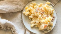 a white plate topped with macaroni and cheese covered in powdered crumbs