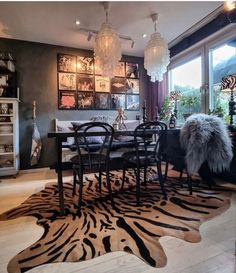 a dining room with zebra print rugs and chandelier hanging from the ceiling