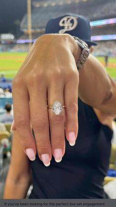 a close up of a person's hand with a diamond ring on their finger