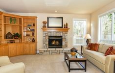 a living room filled with furniture and a fire place in the middle of a room