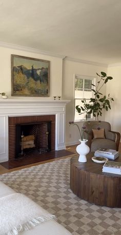 a living room filled with furniture and a fire place under a painting on the wall