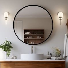 a bathroom with a round mirror on the wall and a sink in front of it