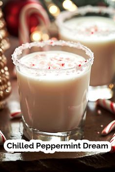 two glasses filled with peppermint cream on top of a table next to candy canes