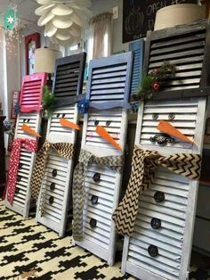 several wooden shutters decorated with ribbons and bows are lined up against a wall in a store