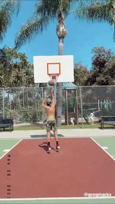 a man is playing basketball on an outdoor court with palm trees in the back ground