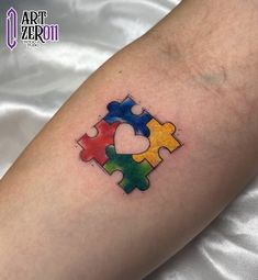 a person with a tattoo on their arm has a puzzle piece in the shape of a heart