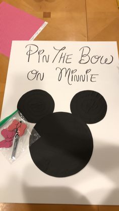 a mickey mouse cut out on top of a paper sign that says pin the bow on minnie