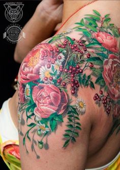 a woman's back with flowers and berries on it