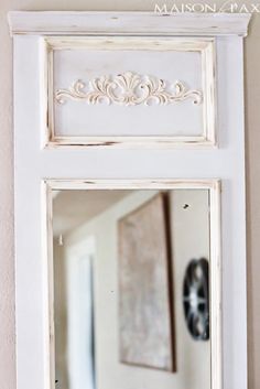 a white framed mirror sitting on top of a wall