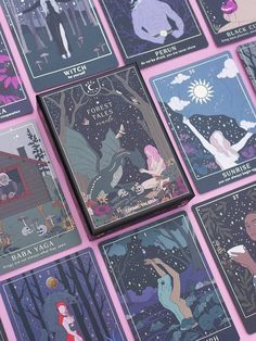 several tarot cards are arranged on a pink surface