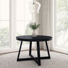 a black table with a white vase on it in front of two windows and a rug