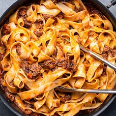 a skillet filled with pasta and meat