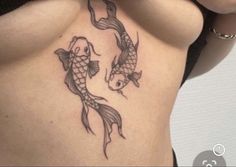 a woman's stomach with two koi fish tattoo on her back and side