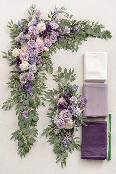 purple flowers and greenery are laid out on the wall