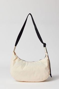 Medium version of BAGGU’s Nylon Crescent Bag, effortlessly casual and large enough to carry more than just the essentials. With an adjustable tonal logo strap, it wears comfortably across the body or on the shoulder for a hands-free experience. Complete with two interior pockets that make it easy to stay organized. Made of recycled heavyweight nylon with a recycled ripstop lining. Content + Care 100% Recycled nylon Machine wash Imported Size Dimensions: 13.75" l x 4" w x 8" h Strap drop: 37.5" M Cream Nylon Everyday Bag, Cream Nylon Bag, Cream Nylon Bag For Everyday Use, Everyday Cream Nylon Bag, Bag Silhouette, Crescent Bag, Stay Organized, Hands Free, Crescent