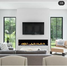 a living room with couches, chairs and a flat screen tv on the wall