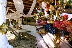 a table with grapes and other fruits on it next to a white draping