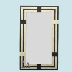 an art deco style mirror with black and white squares on the border, against a light blue background