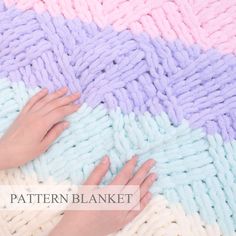 a woman's hands on a multicolored knitted blanket