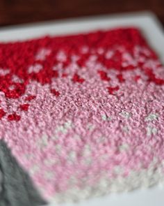 a close up of a piece of crocheted material with red and white colors