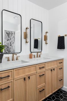 a bathroom with two sinks and mirrors on the wall, along with black and white tile flooring