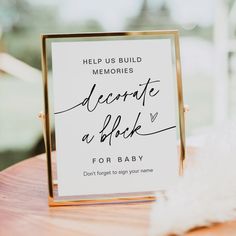 a sign that reads, help us build memories decorate a book for baby on a wooden table