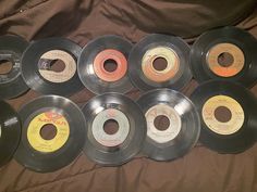 nine old records are lined up on a bed