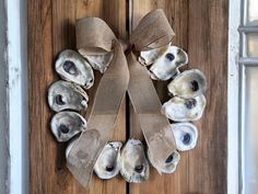 a wreath made out of seashells is hanging on a door with burlocks