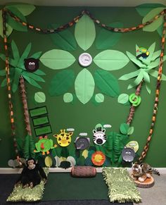 a green wall decorated with jungle animals and trees