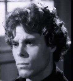 a black and white photo of a man with curly hair