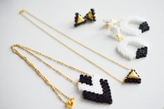 four different necklaces made out of legos on a white surface with gold chains