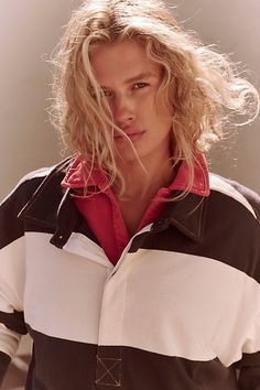 a woman with blonde hair wearing a black and white striped jacket, posing for the camera