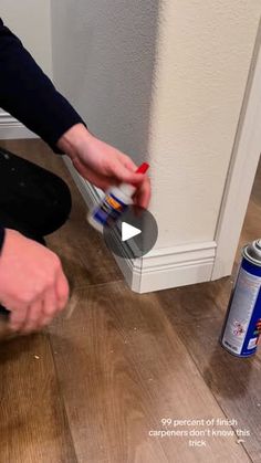 a person is painting the floor with red and white paint in front of a wall