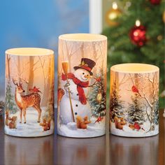 three frosty mugs sitting on top of a table next to a christmas tree