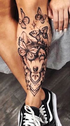 a woman's leg with tattoos and butterflies on it