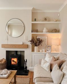 a living room filled with furniture and a fire place in front of a wall mounted mirror