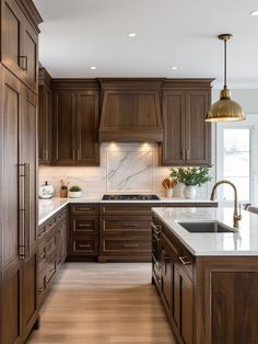 a kitchen with wooden cabinets and marble counter tops