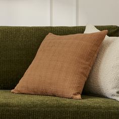 two pillows sitting on top of a green couch