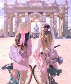 two girls standing next to each other with bicycles in front of an arch and building