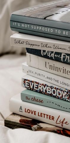 a stack of books sitting on top of a bed next to a white pillow with the words, it's not supposed to be there