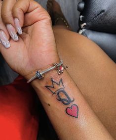 a woman's arm with a tattoo on it and a small red heart in the middle