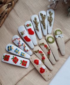 six christmas themed wooden clothes pins sitting on top of a cloth covered table next to a wicker basket