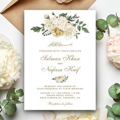 a wedding card with flowers and greenery on it