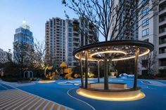 an outdoor play area in the middle of a city at dusk with children's toys