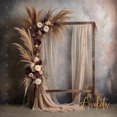 an old photo frame with flowers and feathers on the floor next to a curtained window